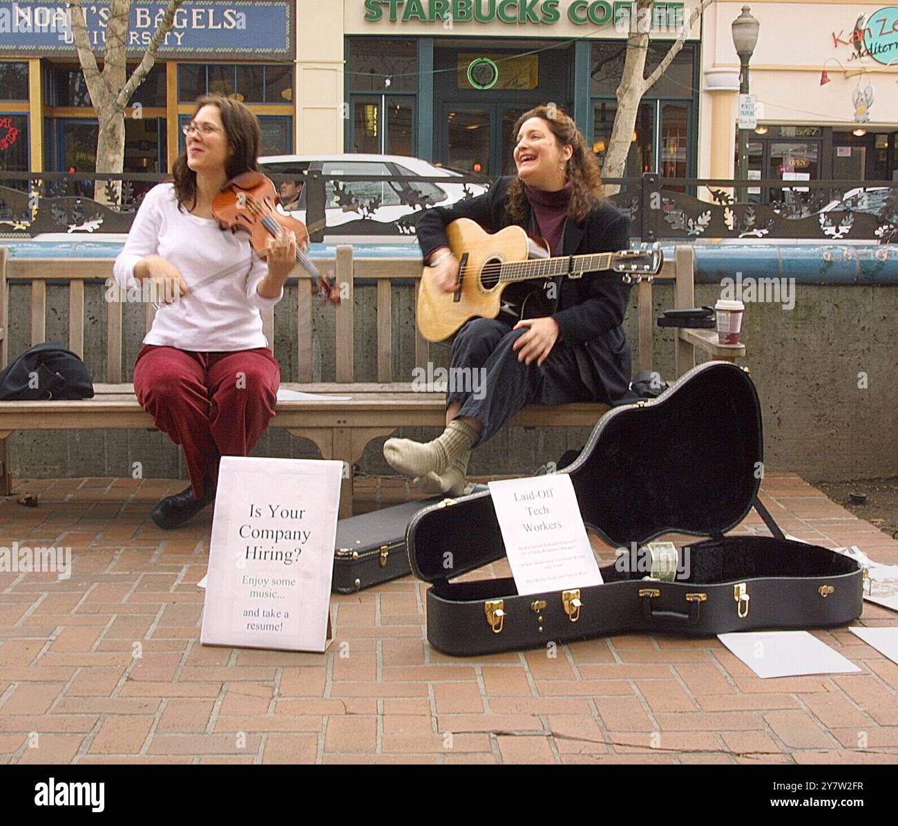 Palo Alto, California,--(Left to right) Valarie Price a laid-off software engineer from Belmont, Calif., and Beneta Kenn a laid-off high-tech public relation manager from Menlo Park, Calif,, now enterianing passersby on University Avenue in downtown Palo Alto with Celtic music and resumes. They were hoppiing to catch the eye of high-tech executives going to lunch. So fare no job offers but it better then setting at home waiting for the phone to ring. They have meet other unemployed people which helps their spirts. Photo taken on Friday, February 15, 2002 ) Stock Photo