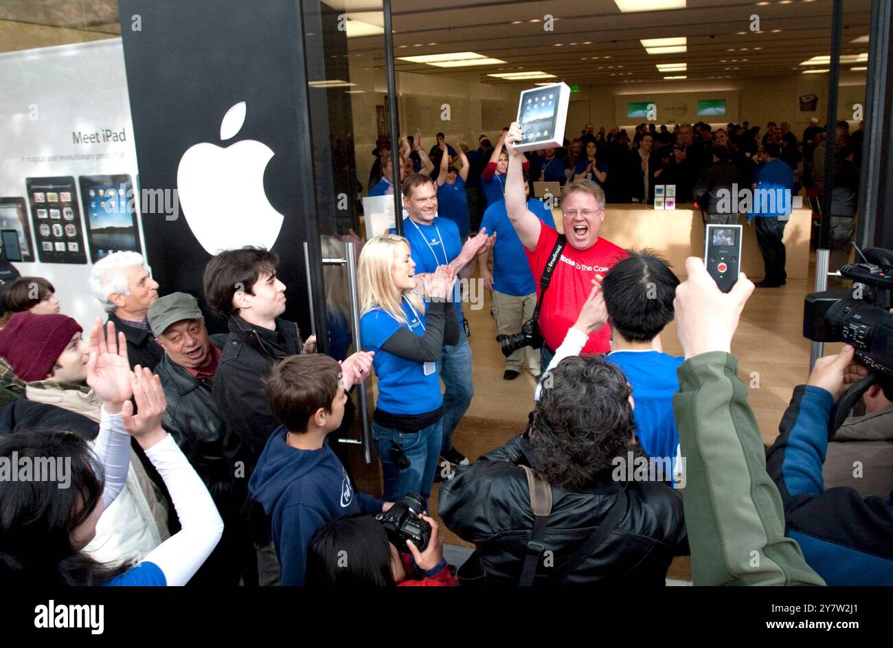 Palo Alto, California - April 3, 2010 Man walking out of Apple store holding up his new ipad. He started waiting on line at 11AM on Friday, April 2, 2010 to be the first in Palo Alto to own a new IPad. Stock Photo