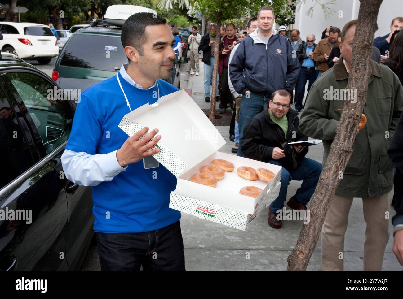 Palo Alto, California - April 3, 2010   Hundreds of people wait in outside Apple Store on University Avenue in Palo Alt0 , to buy the new iPad. Robert Scoble started waiting line at 11AM on Friday, April 2, 2010 to be the first in Palo Alto to own a new IPad.  Employees serving Krispe Kreme donuts to crowds waiting in line Stock Photo