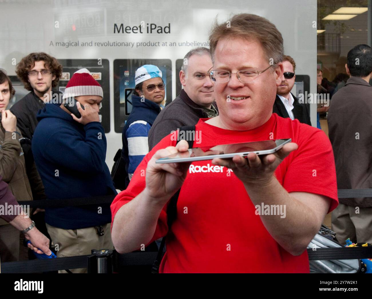 Palo Alto, California - April 3, 2010 Man walking out of Apple store holding up his new ipad. He started waiting on line at 11AM on Friday, April 2, 2010 to be the first in Palo Alto to own a new IPad. Stock Photo