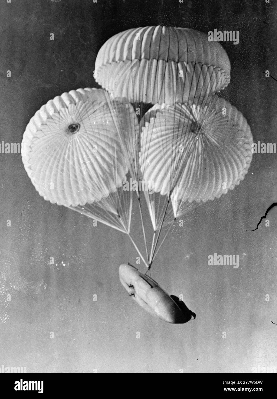 AIR BORNE LIFEBOAT FOR SEA RESCUE SERVICE Developed by the Emergency Rescue Branch of the Personnel Equipment Laboratory,  this airborne lifeboat is now being used by the Americans for sea rescues from the air.  27 feet long and weighing over one ton, the lifeboat is secured under the bomb bays of a B17.  It is carried by three parachutes which afterwards submerge and serve as  a sea anchor.  Powered with two 5hp engines the craft will do eight miles per hour.  Canvas covers help to protect the occupants from bad weather.  Photo Shows:  The parachutes have been released and  the  air-borne lif Stock Photo