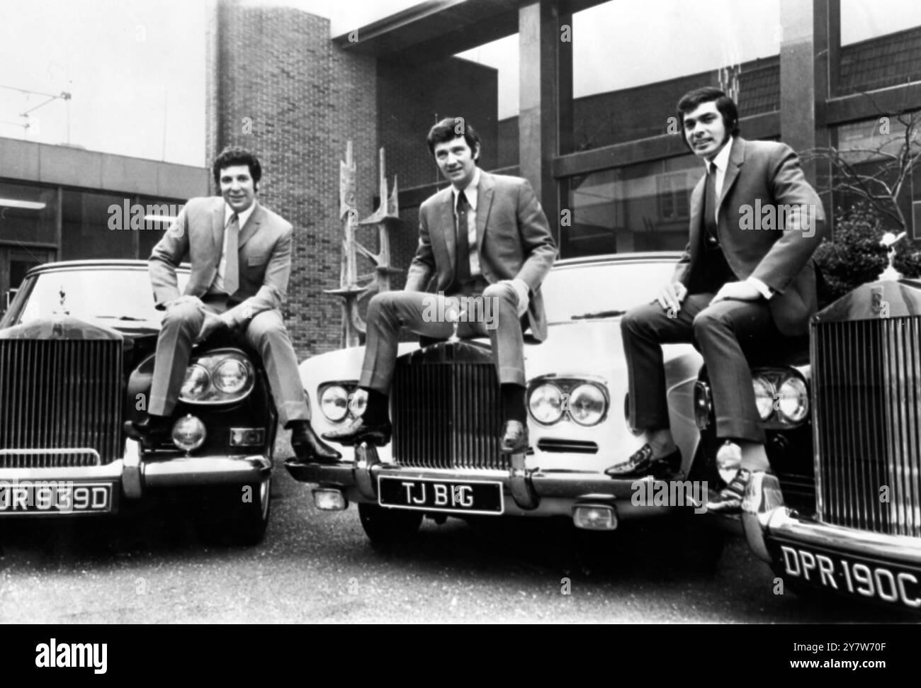 It must be the musical world, where the money is. The trio sitting on their expensive cars are top singers Tom Jones (left) and Engelburt Humperdinck (right) with their manager Gordon Mills (centre). Their cars that they are using as seats are all of the Rolls Royce range, two are Silver Shadow convertibles and the third a Silver Cloud. The total estimated value of these three seats is around 65000 dollars, Elstree, Hertfordshire, England.6 February 1969 Stock Photo