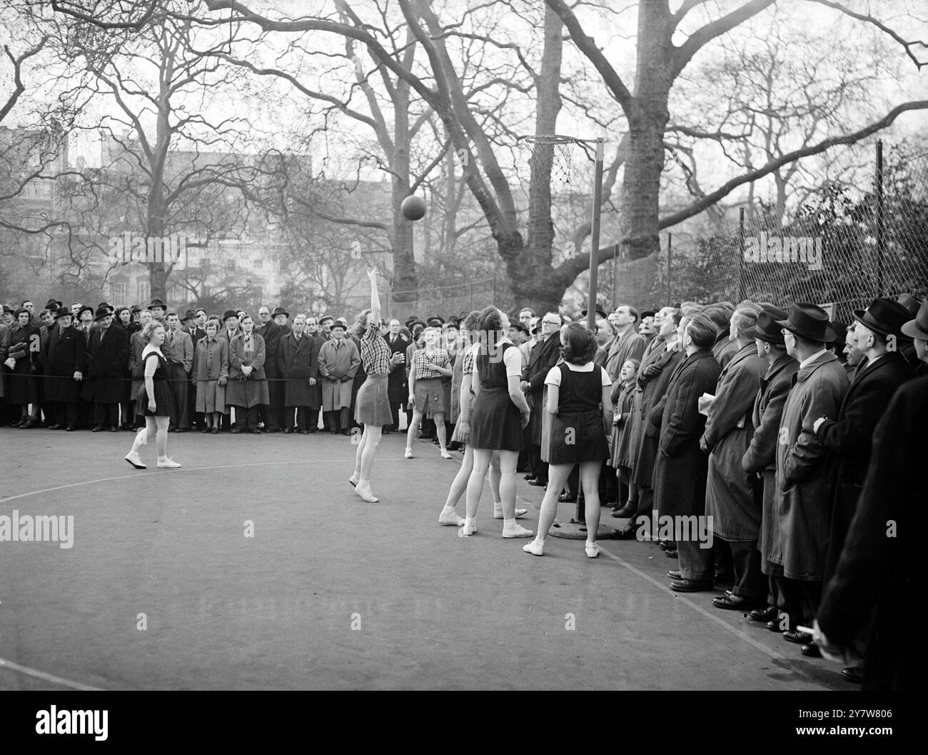 Today's mild weather which gave a preview of Spring, drew lunch hour crowds to Lincoln's Inn Fields to watch City girl workers playing netball. These two teams are Zurich House and Lincoln Inn.20 February 1953 Stock Photo