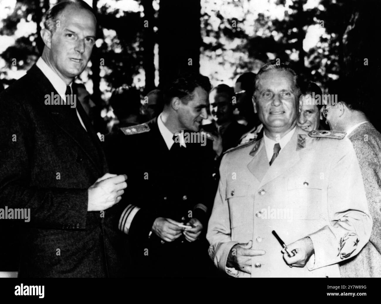 Jugoslavia's Marshal Tito (right) standing with his guest, Mr Fitzroy Maclean, British Member of Parliament, soldier and author, who was his guest during the last days of the Jugoslavian Army manoeuvres.Mr Maclean (extreme left) was chief of the British Military Mission to the Partisan headquarters in Jugoslavia during the war. In the centre of the picture is Vice- Admiral Srecko Manola. 28 September 1953 Stock Photo