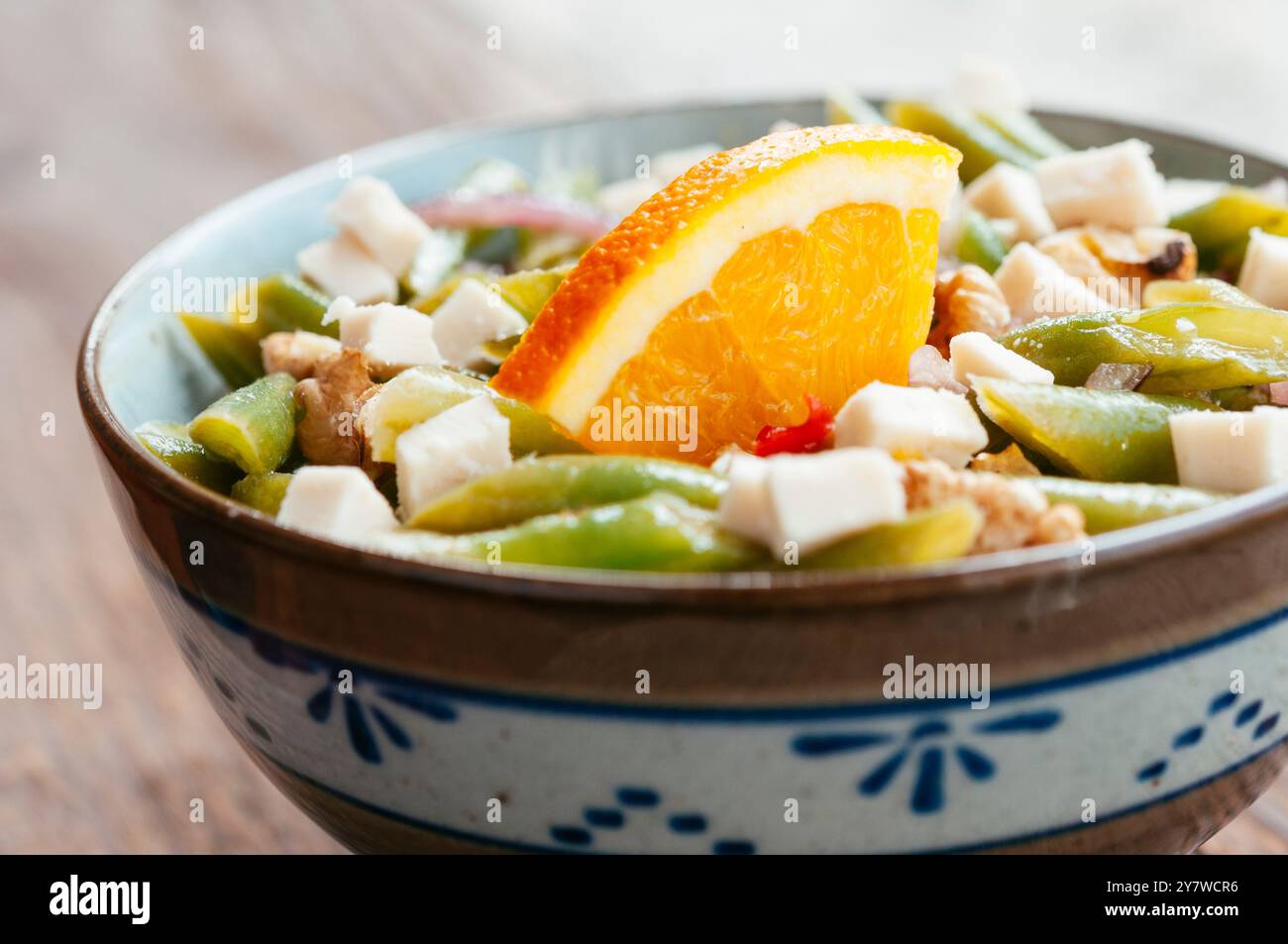 Bowl with a green bean and walnut salad with soy cheese pieces. Stock Photo