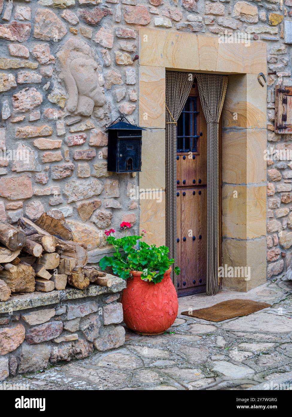 Rustic Stone House Entrance with Wooden Door and Flower Pot Stock Photo ...
