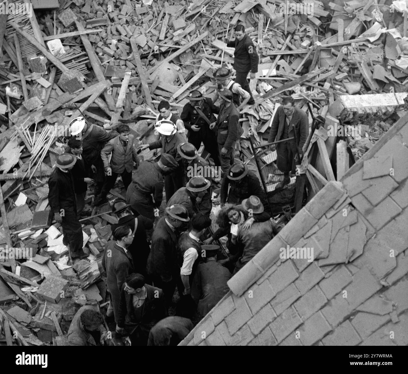 Rescuers pull a survivor from her bomb damaged house after an enemy air ...