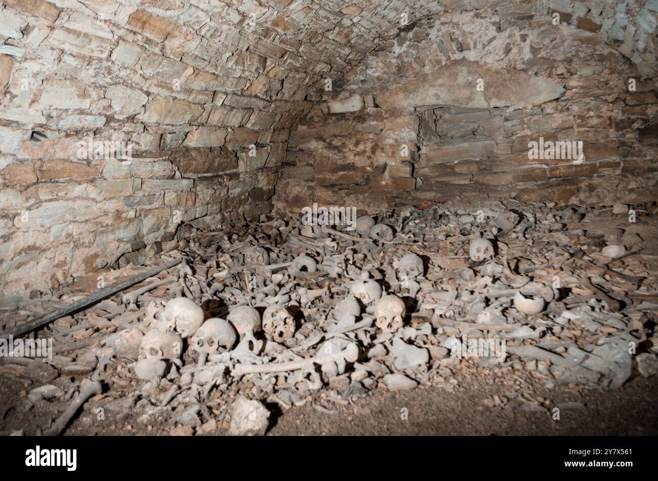 Haunting Remains: A Glimpse into an Ancient Catacomb Filled with Human Skeletal Remains. Stock Photo