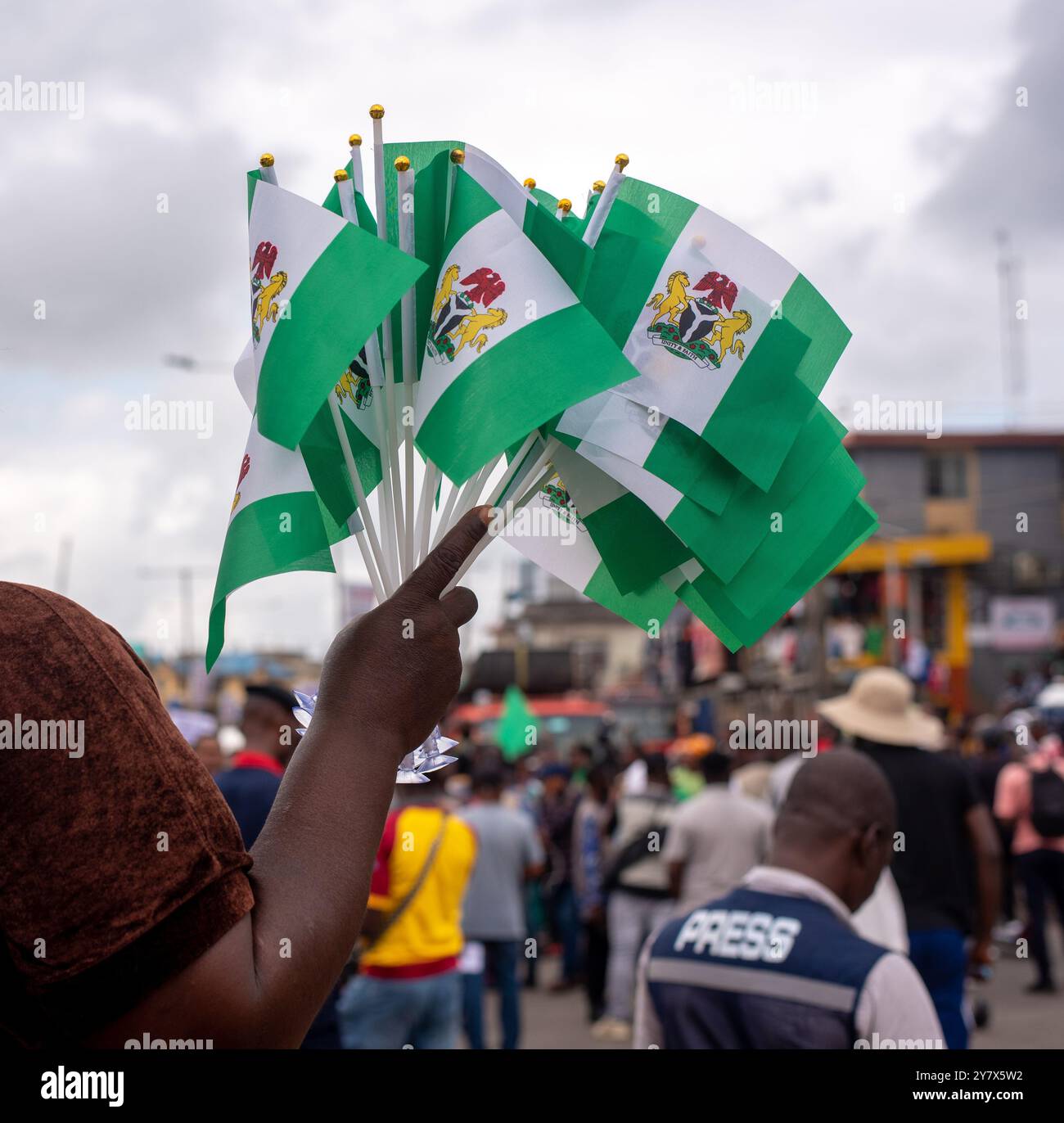 A woman holds out Nigeria Flags for sale in Lagos on Tuesday, October 1, 2024.  Nigerians are out on Independence Day to protest bad governance and hi Stock Photo