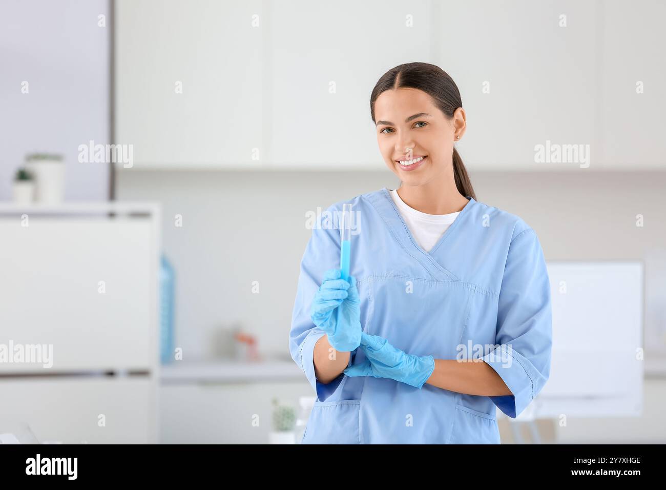 Happy female young scientist with test tube of water sample in research ...