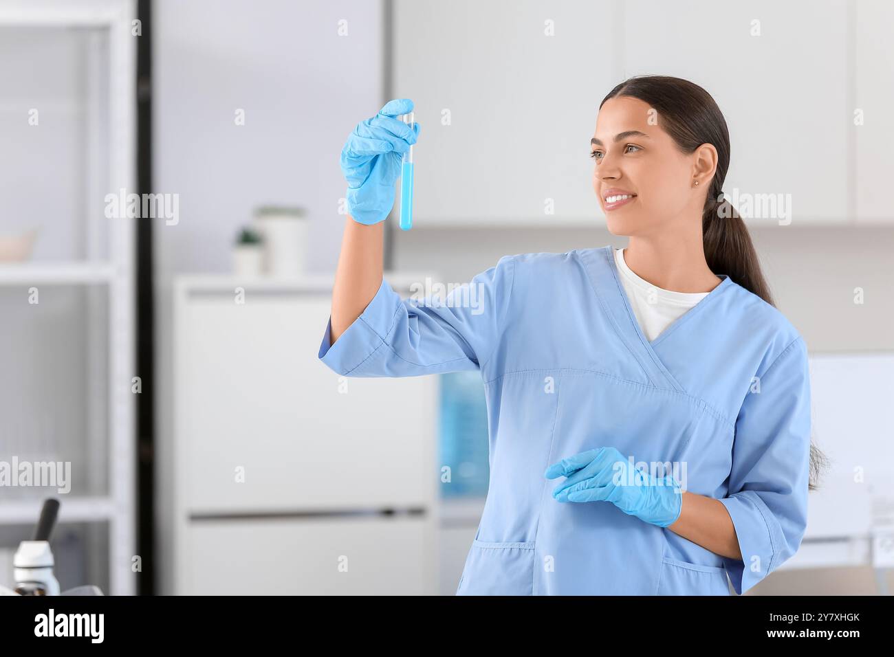 Happy female young scientist with test tube of water sample in research ...