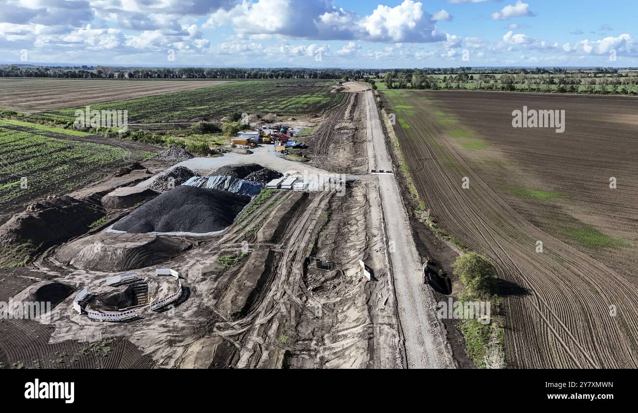 Construction vehicles are parked at an access road under construction ...