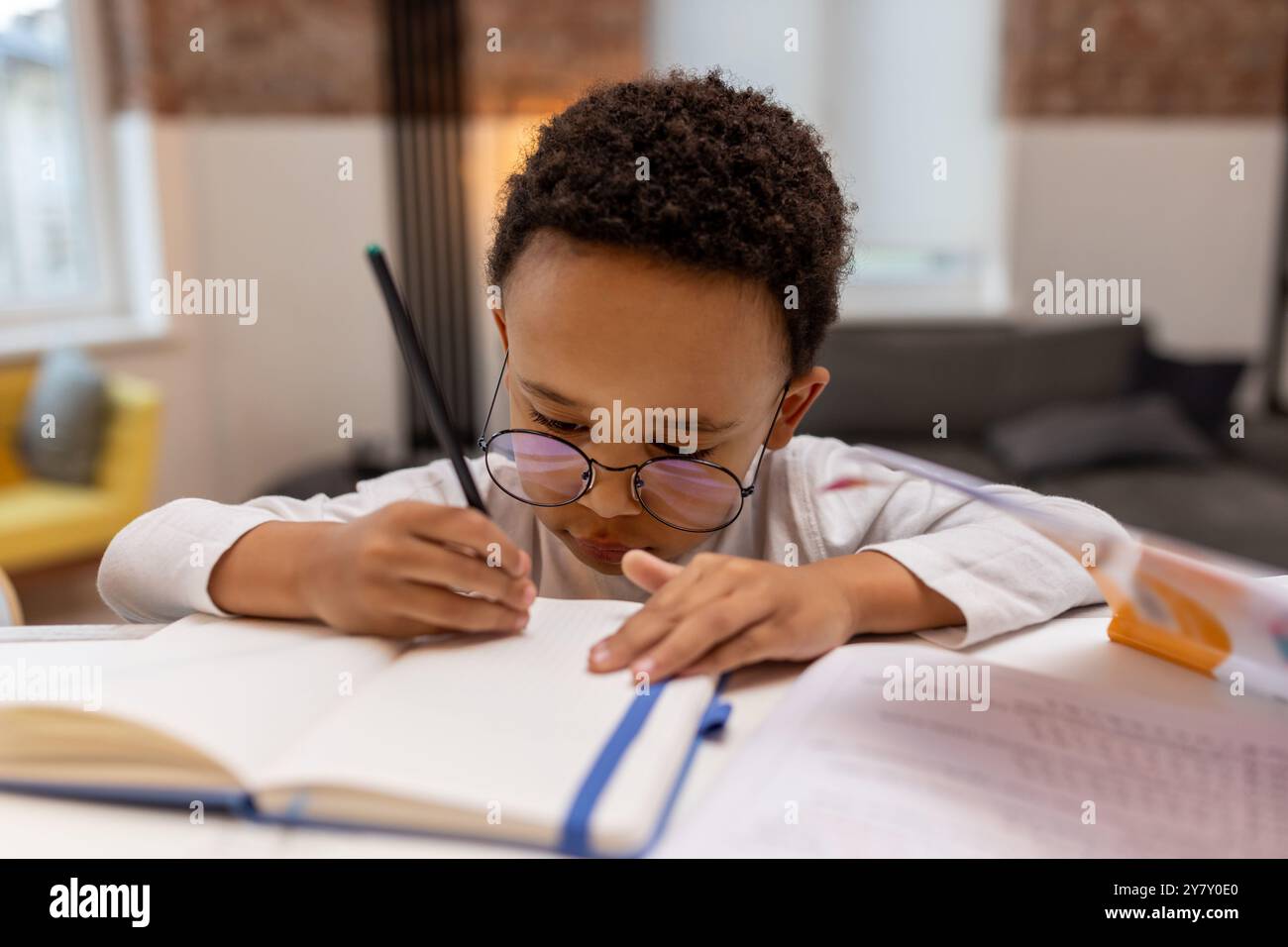 Dark-skinned cute boy doing lessons and looking involved Stock Photo