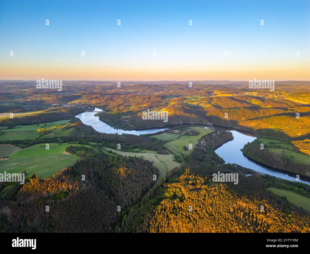 An aerial view of the Vltava River winding through the rolling hills of ...