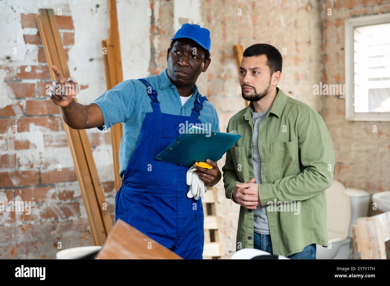 Builder having conversation with designer about working plan Stock Photo
