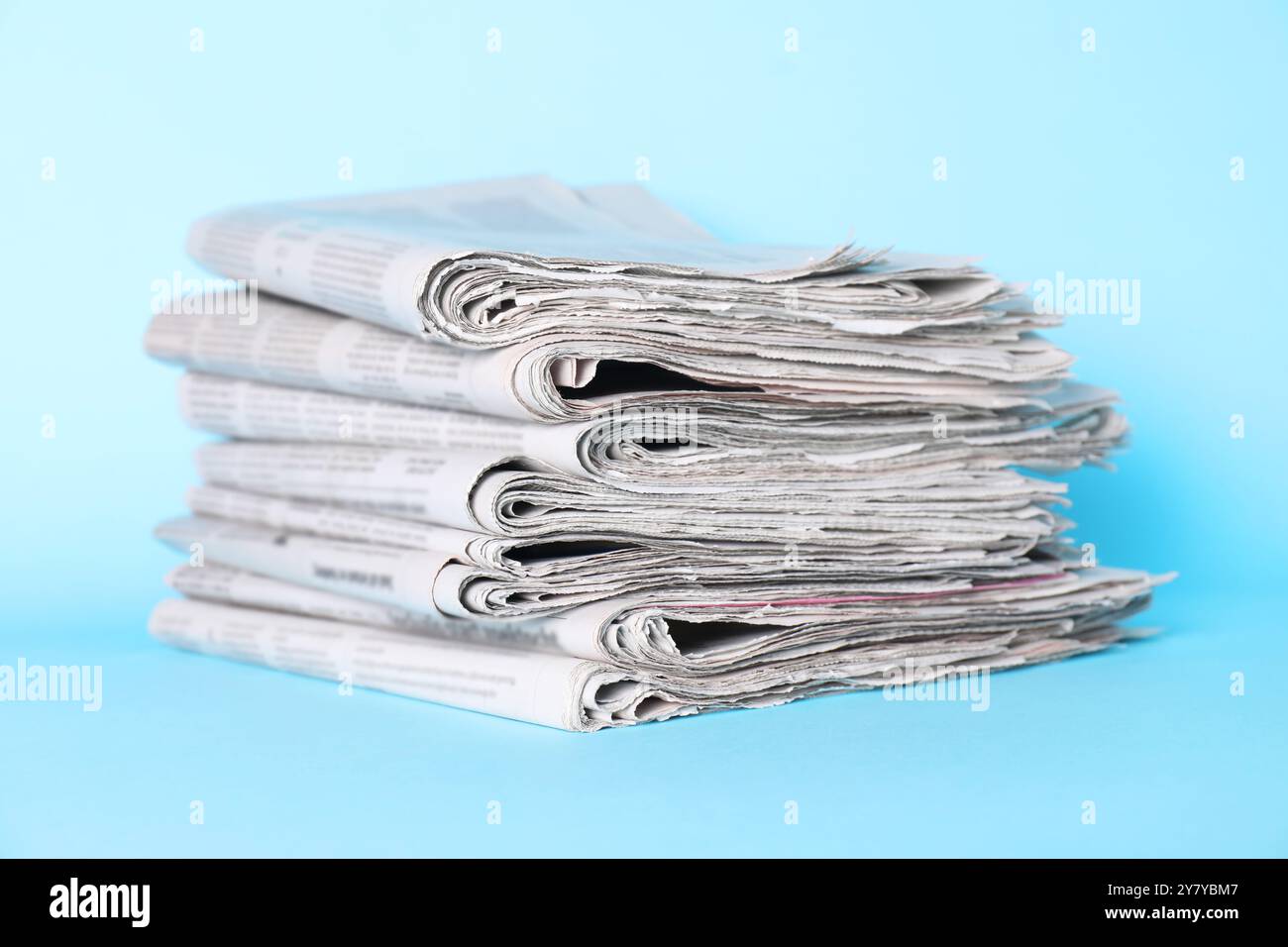 Stack of newspapers on light blue background Stock Photo