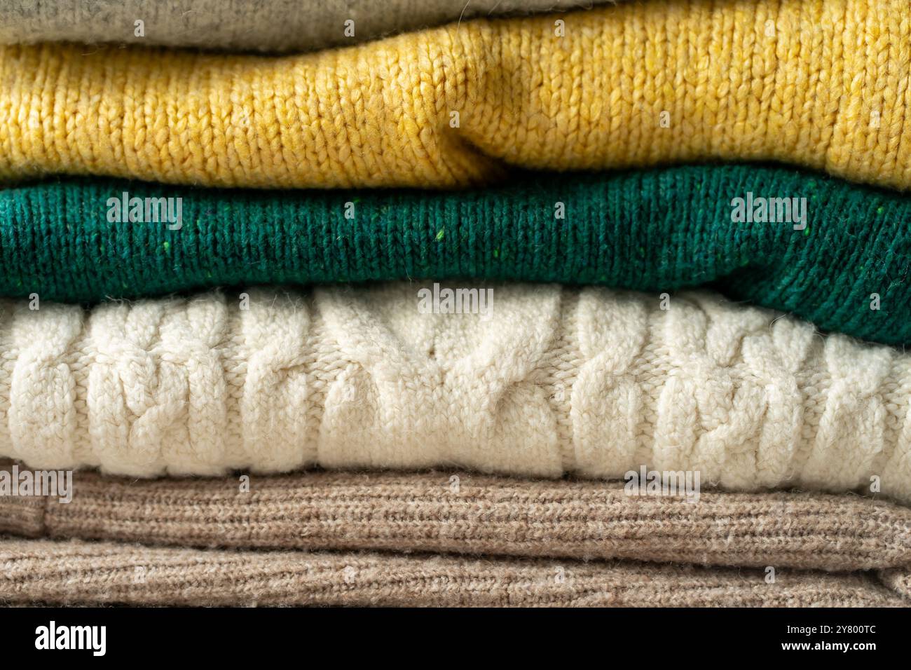 A stack of knitted sweaters on the table. Background textures. Stock Photo
