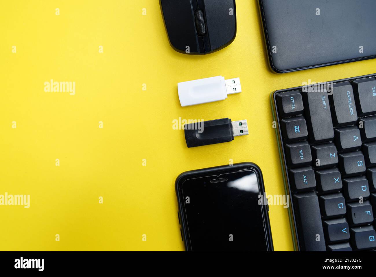 keyboard, mouse, smartphone and flasdisk on yellow background Stock Photo