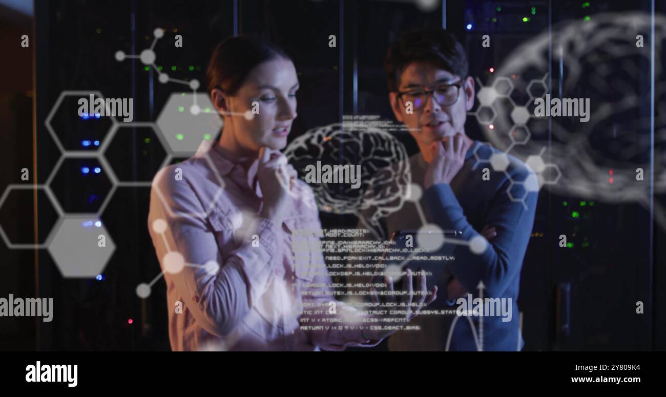 Image of data processing with brains over diverse colleagues using tablet in server room Stock Photo