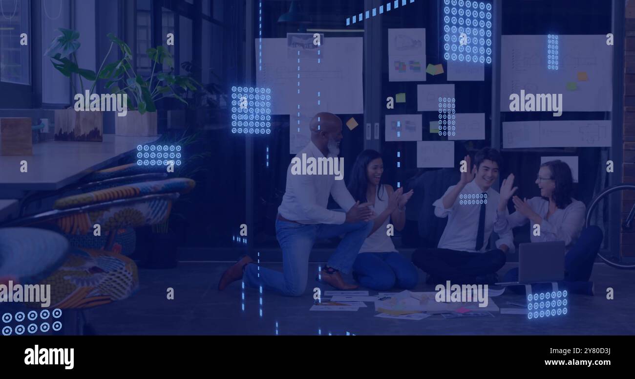 Data processing image over diverse team collaborating on floor in modern office Stock Photo