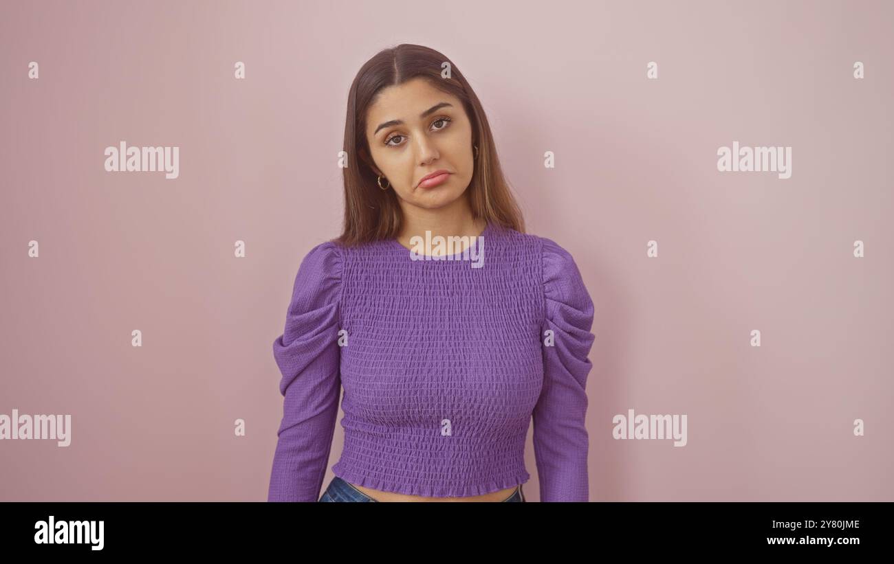 Hispanic Poses A young hispanic woman poses against a pink isolated background ...