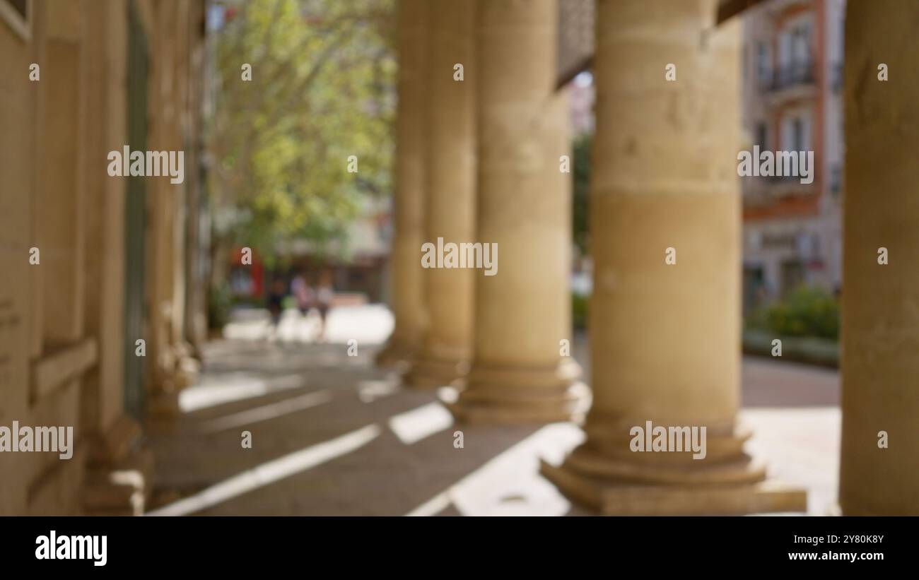 Outdoor scene with blurred columns and defocused background in sunlight ...
