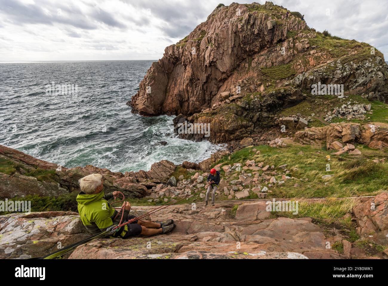 Outdoor provider Kullabergsguiderna offers various outdoor activities along the Kullen peninsula, such as abseiling or cave hikes. You can practise abseiling on the rugged rocks of the Kullaberg peninsula under the guidance of a guide. Italienska vägen, Mölle, Skåne län, Sweden Stock Photo