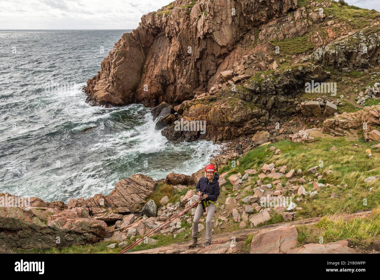 You can practise abseiling on the rugged rocks of the Kullaberg peninsula under the guidance of a guide. Italienska vägen, Mölle, Skåne län, Sweden Stock Photo