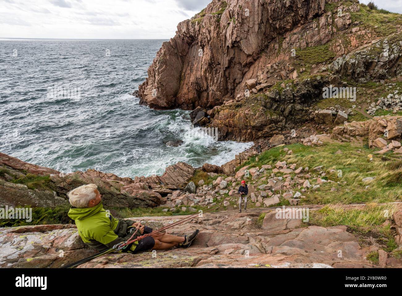 Outdoor provider Kullabergsguiderna offers various outdoor activities along the Kullen peninsula, such as abseiling or cave hikes. You can practise abseiling on the rugged rocks of the Kullaberg peninsula under the guidance of a guide. Italienska vägen, Mölle, Skåne län, Sweden Stock Photo