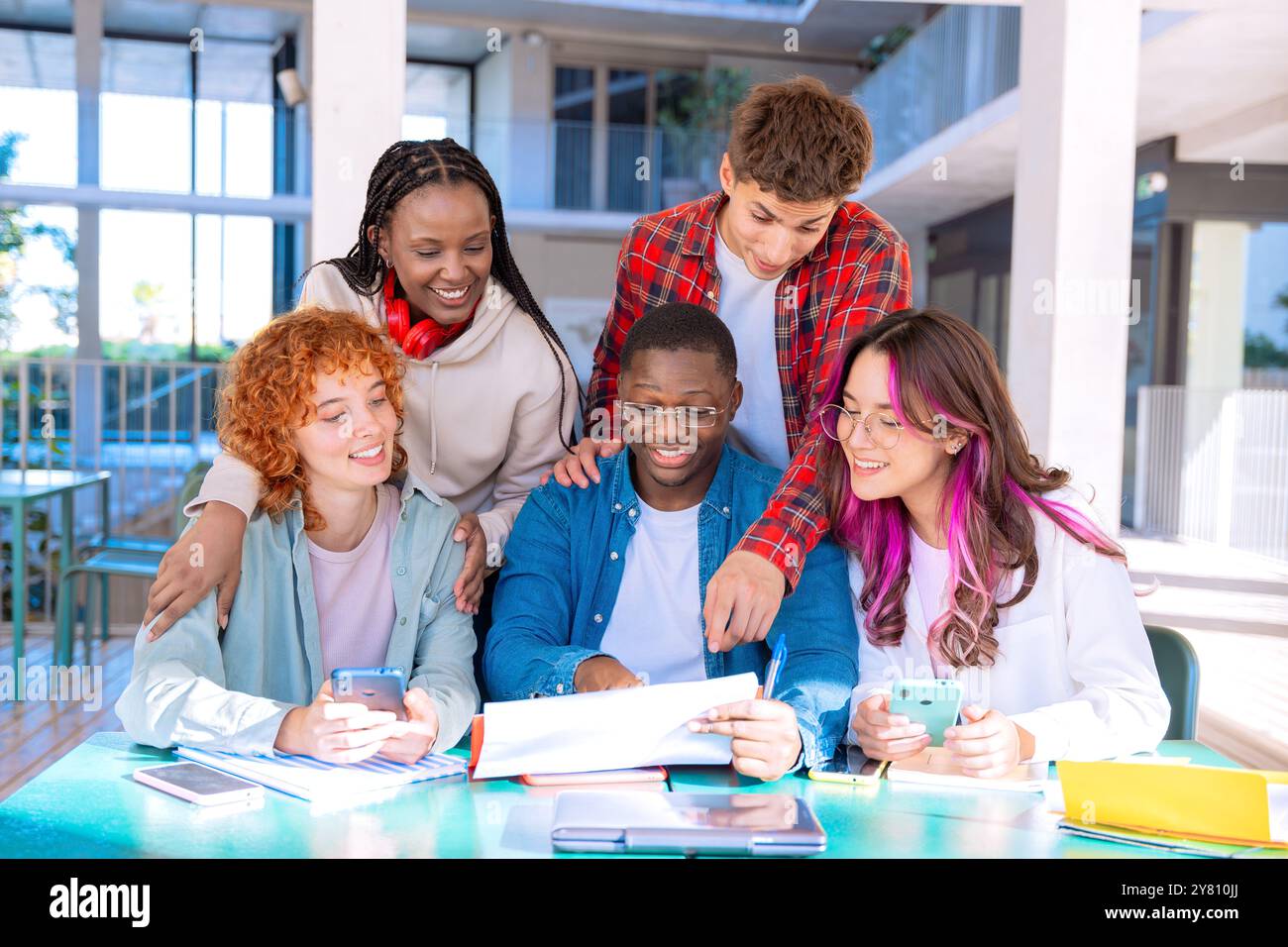Happy diverse group of students studying in the library Stock Photo - Alamy