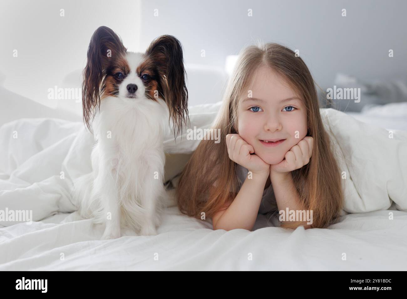 portrait of little preschool girl lying in bed with her cute dog Stock ...