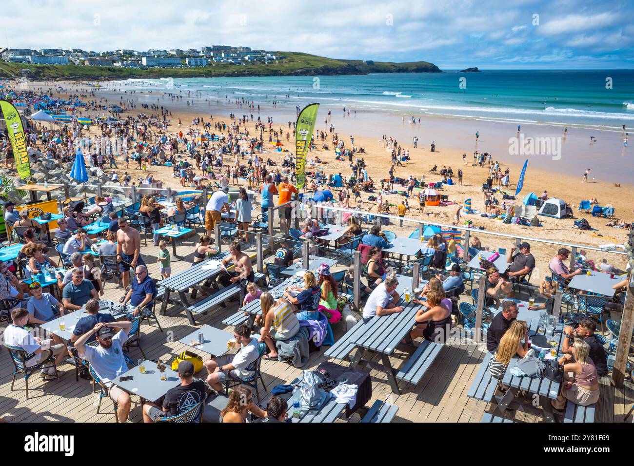 Holidaymakers enjoying the summer sunshine sitting on the outdoor decking area of the Fistral Beach Bar in Newquay in Cornwall in the UK. Stock Photo