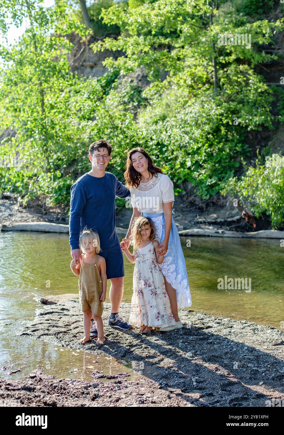 A family launching a kayak from a sandy riverbank into a calm lake in Northern California