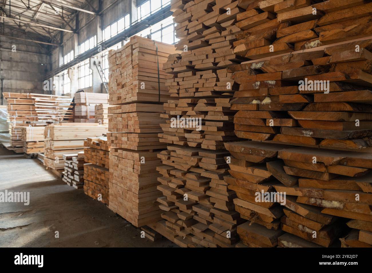 Stacked wooden planks close-up at lumber warehouse. Wood industry ...