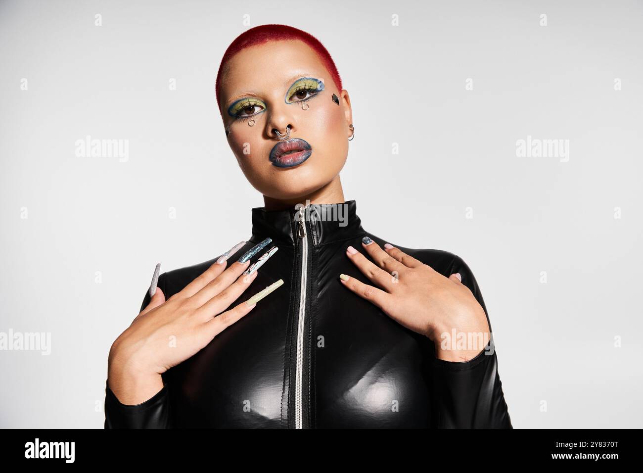 A striking young woman with short pink hair and bold makeup confidently ...