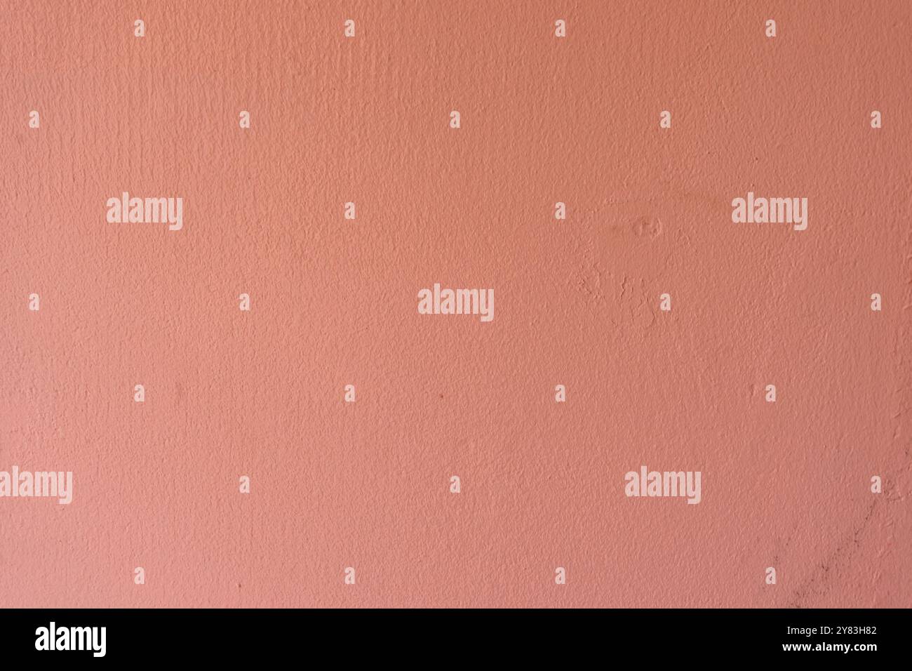 Minimalist textured pink wall under soft lighting. Stock Photo