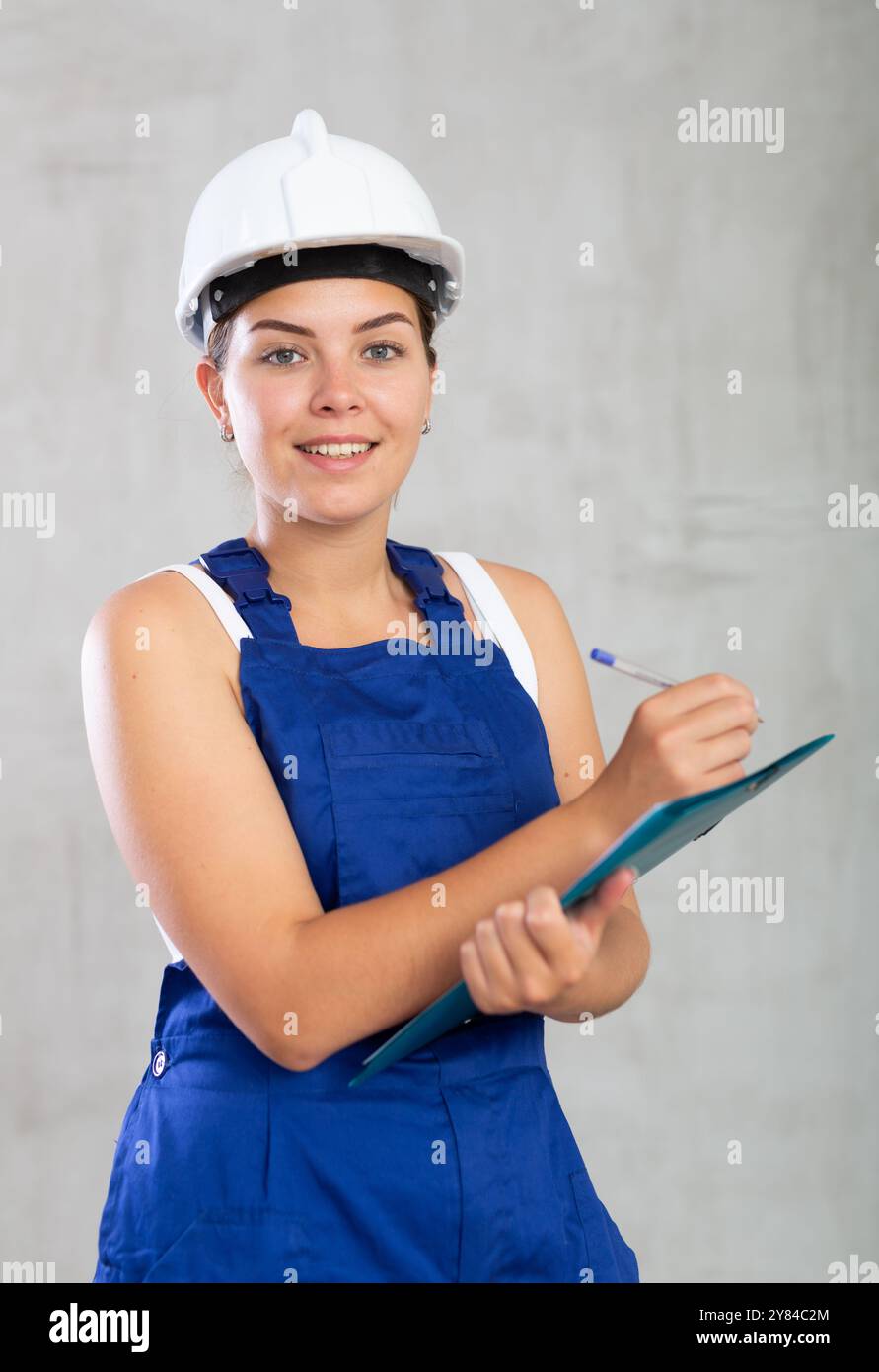 Young Woman In Work Overalls Making Notes Stock Photo Alamy Young woman in work overalls making notes stock photo alamy