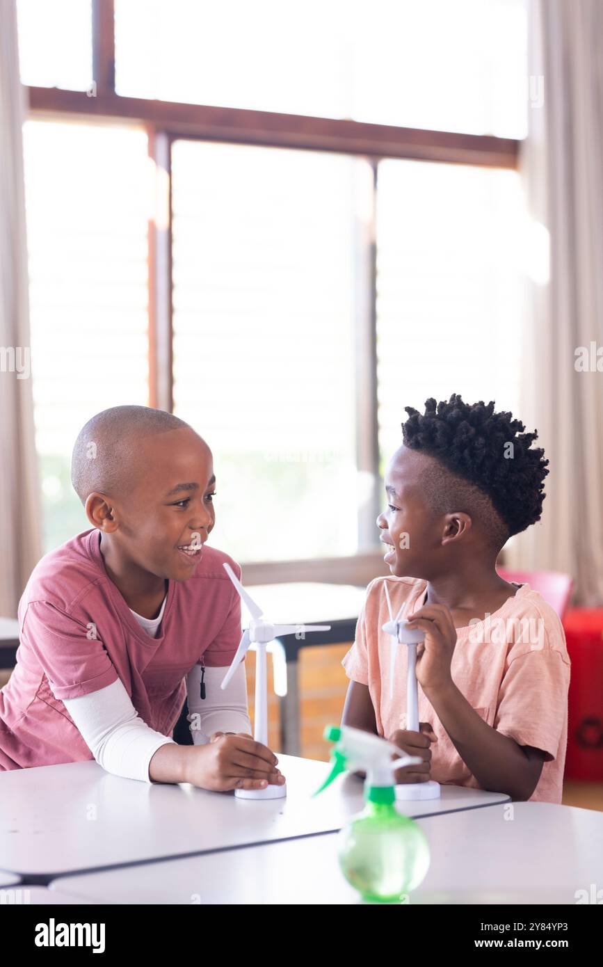 In school, two african american boys discussing wind turbine models in classroom Stock Photo