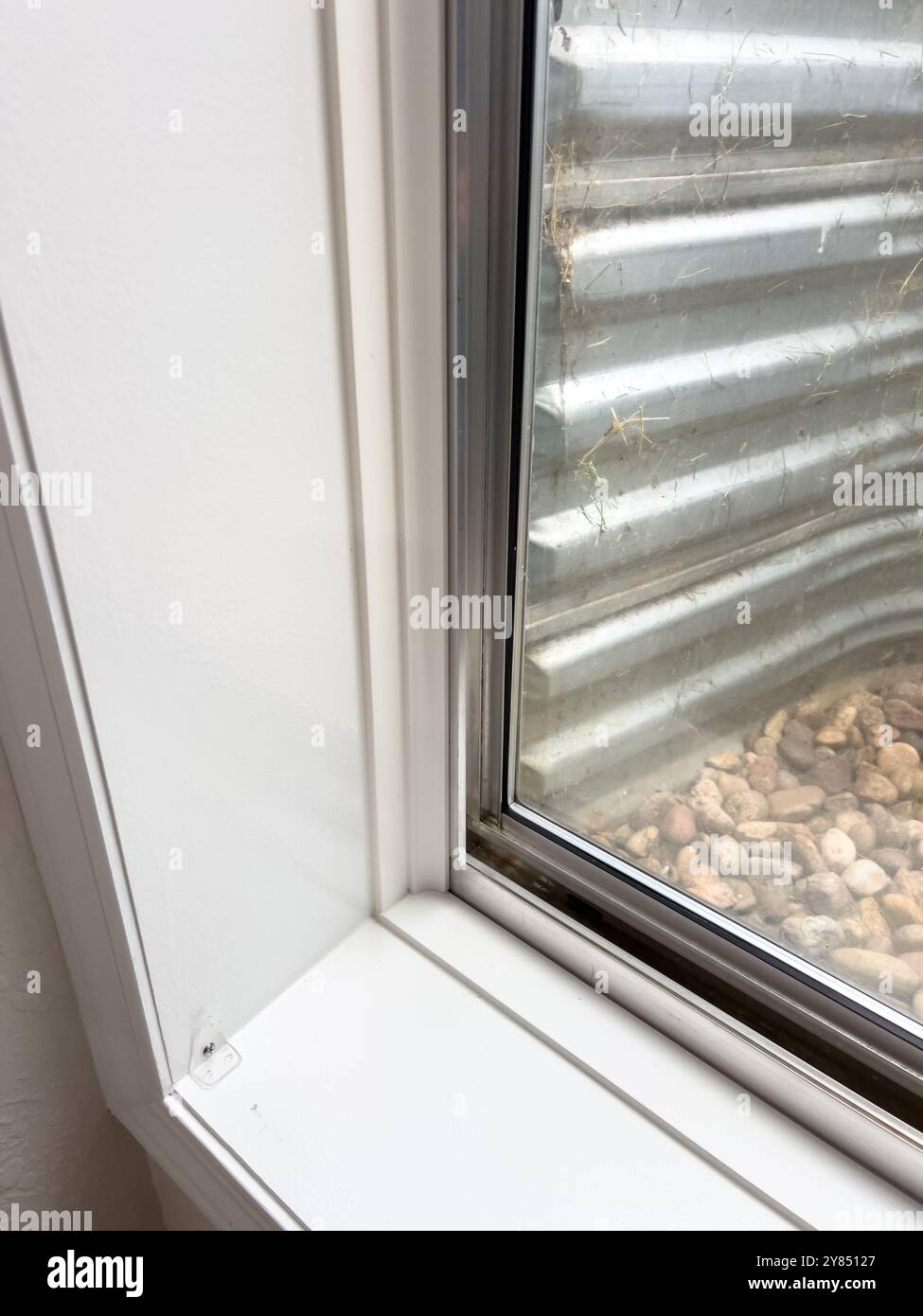 Matt Rocks A Window Basement Window with Metal Window Well and Rocks Stock Photo - Alamy
