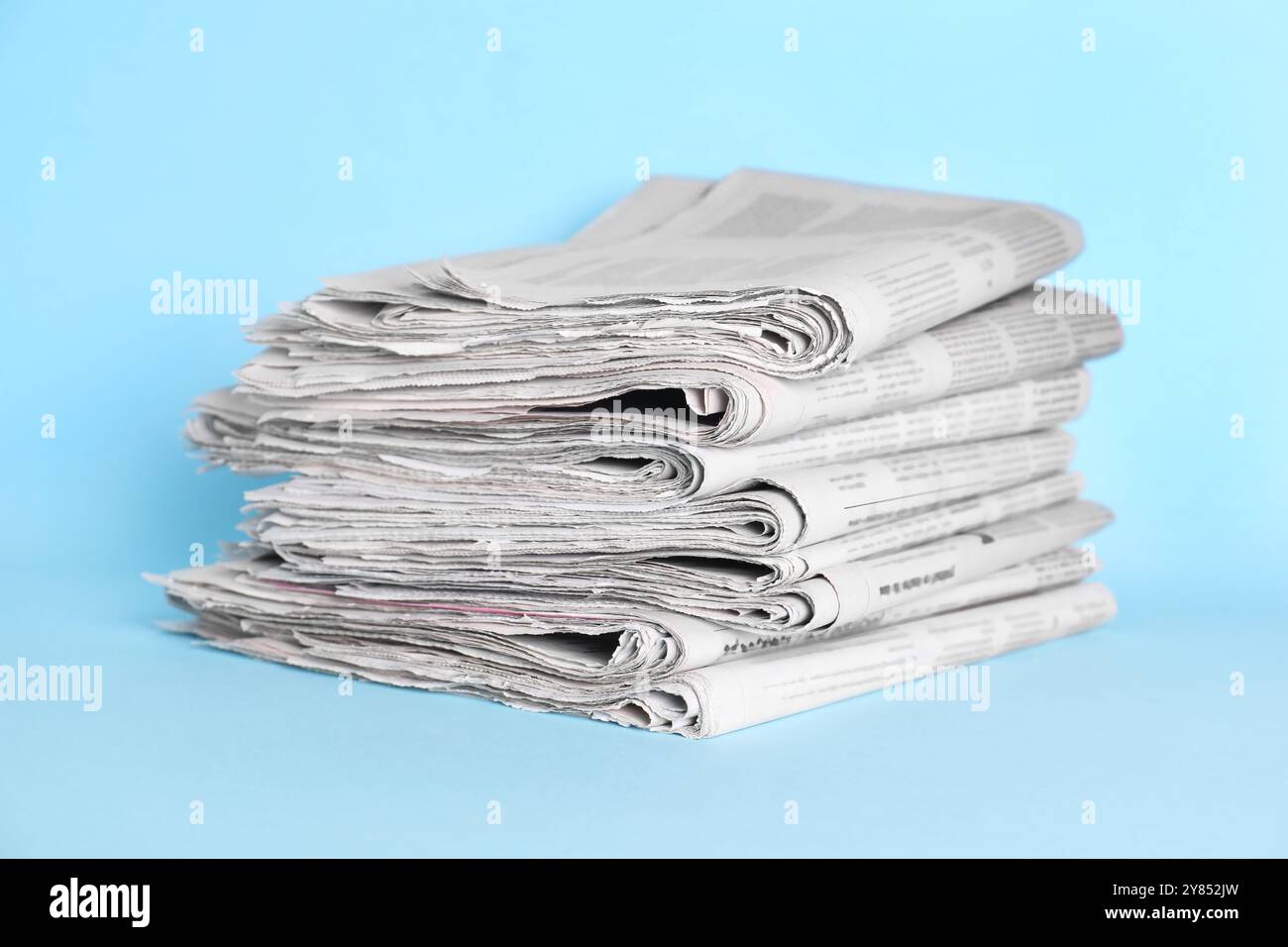 Stack of newspapers on light blue background Stock Photo