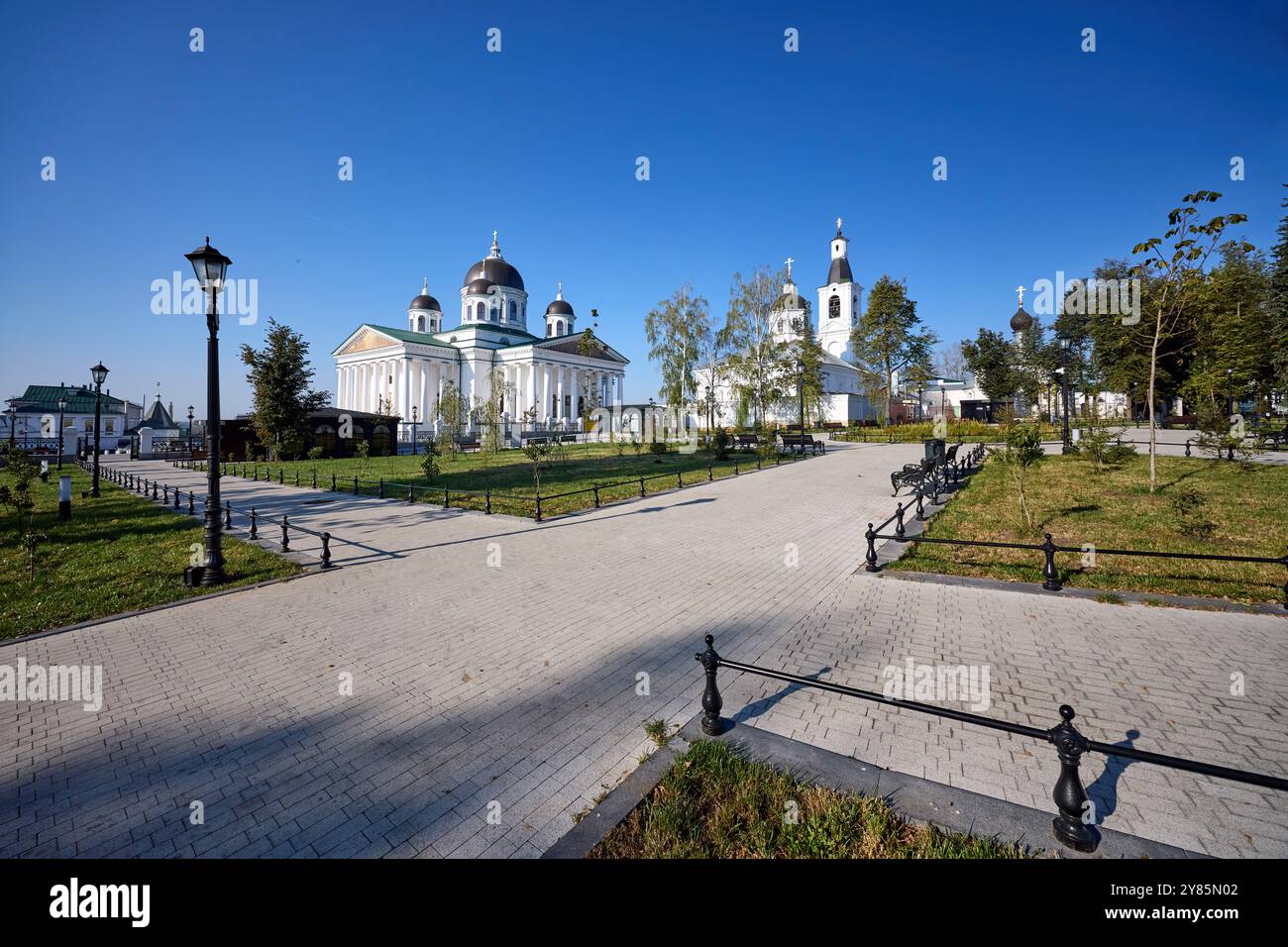 Majestic cathedral with domes against blue sky in Arzamas, surrounded by lush gardens and pathways, blending architectural beauty with tranquil urban Stock Photo