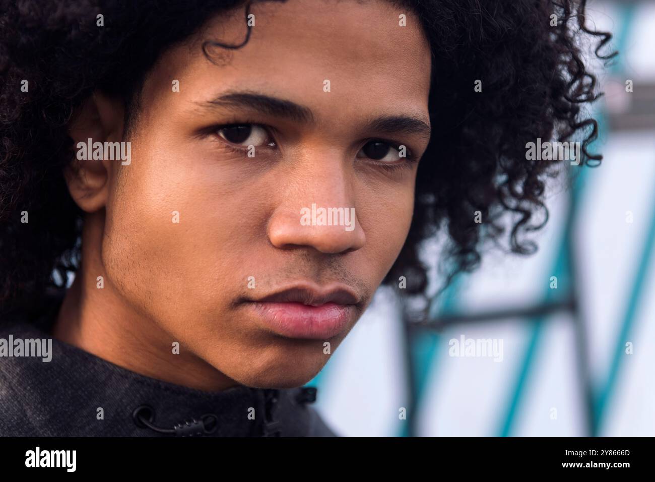 curly haired black male teenager looking at camera Stock Photo