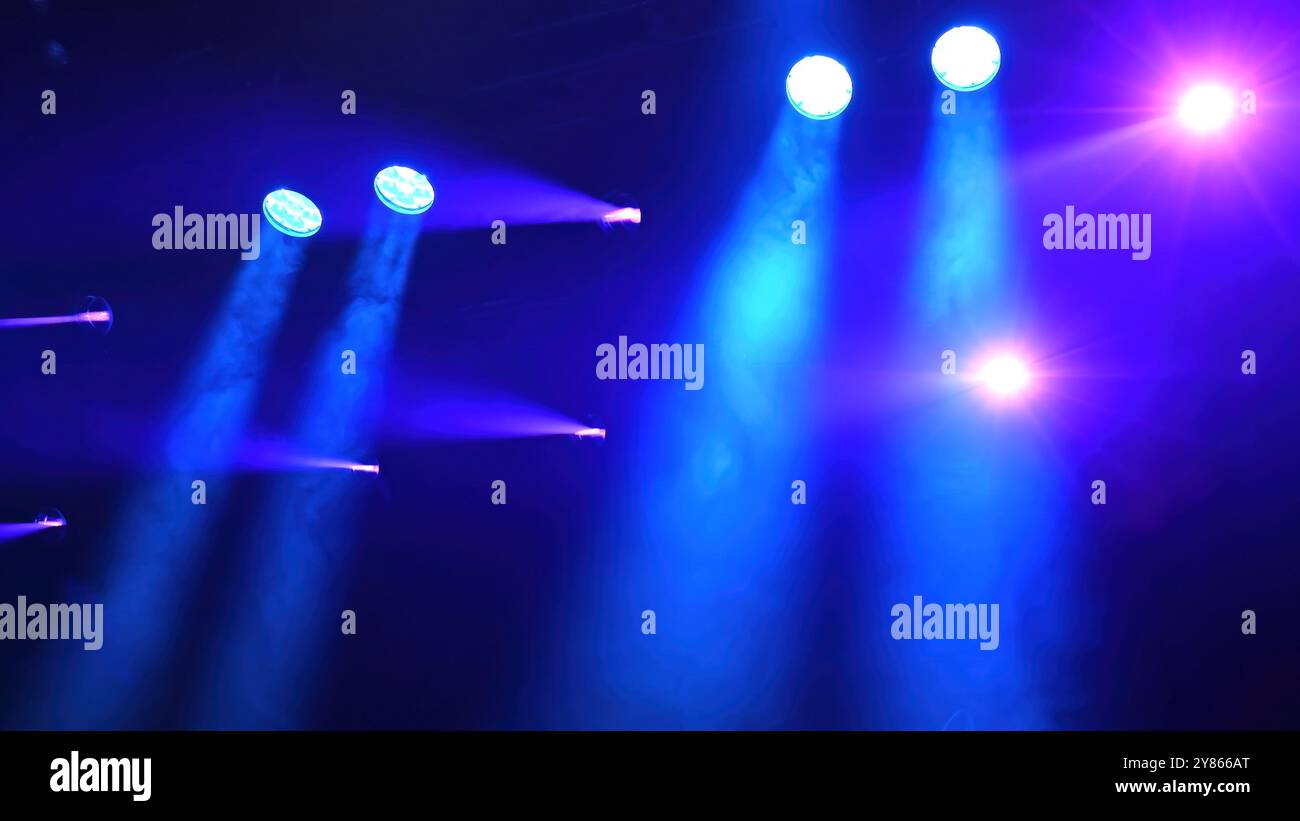 blue spotlights over the stage working during the concert Stock Photo