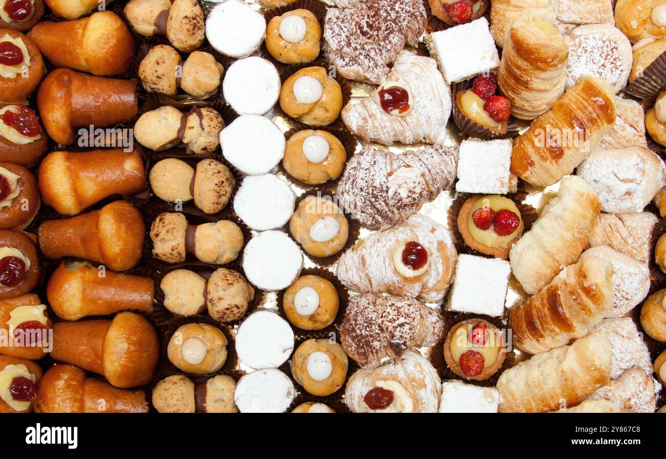 Mouthwatering assortment of sweet pastries arranged in rows, showcasing ...