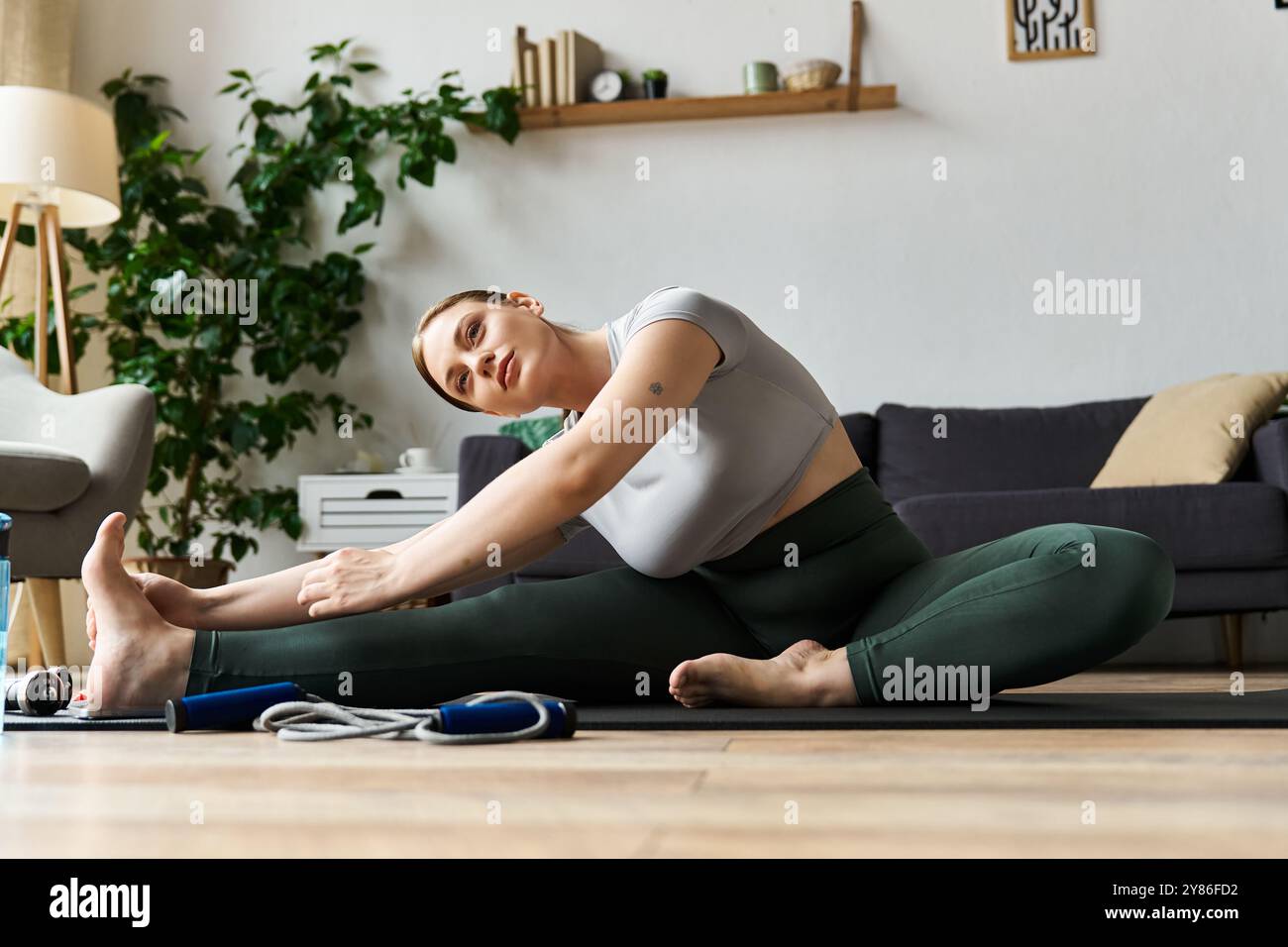 A young woman embraces her workout routine at home, stretching ...
