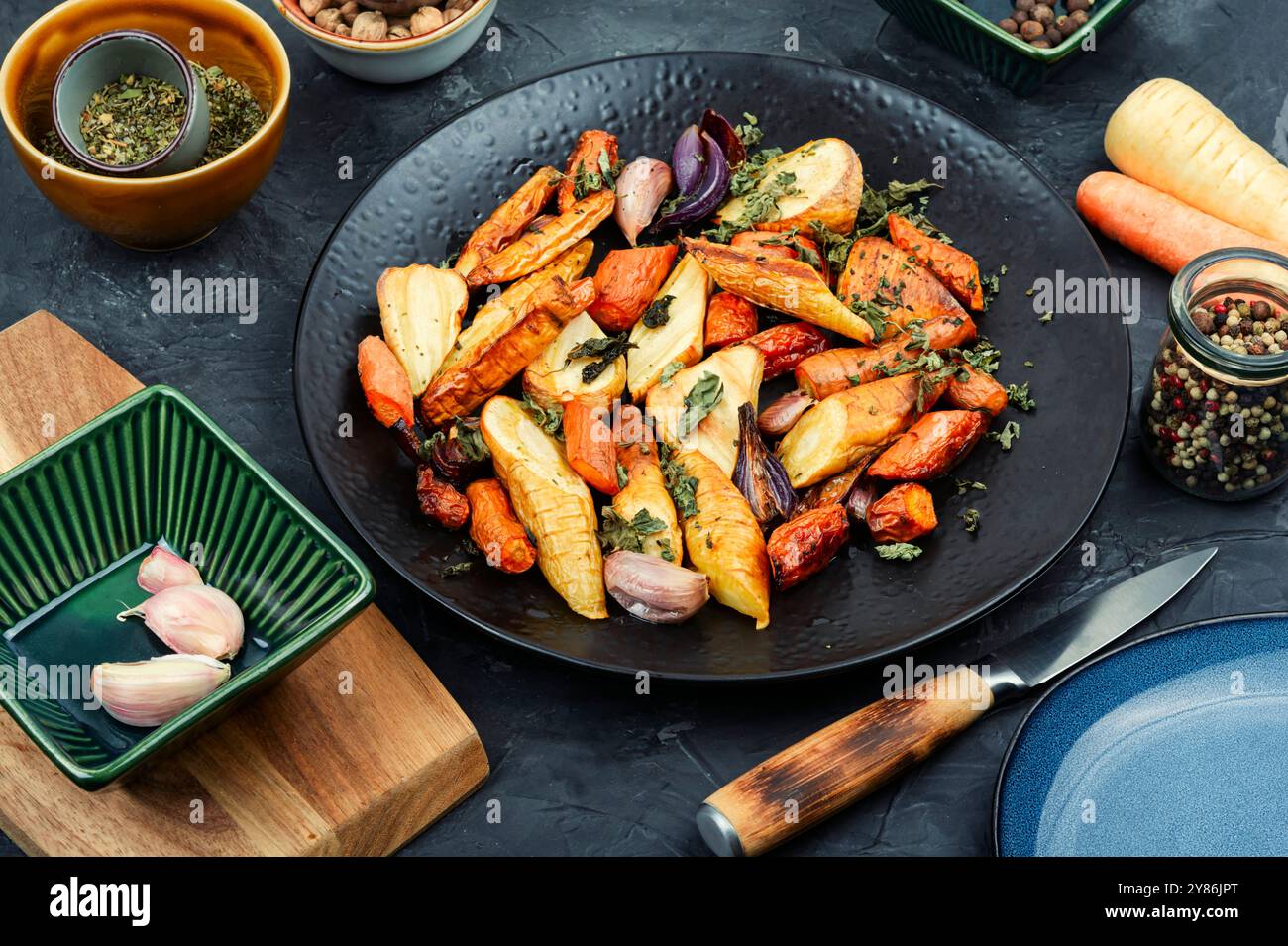 Winter vegan food of baked parsnip root and carrots. Roasted root vegetables. Stock Photo