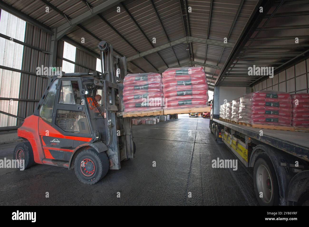 A forklift truck loading a lorry with bags of produce at the cement production facility at Heidelberg Materials’ Padeswood Works in Mold, Flintshire, Stock Photo