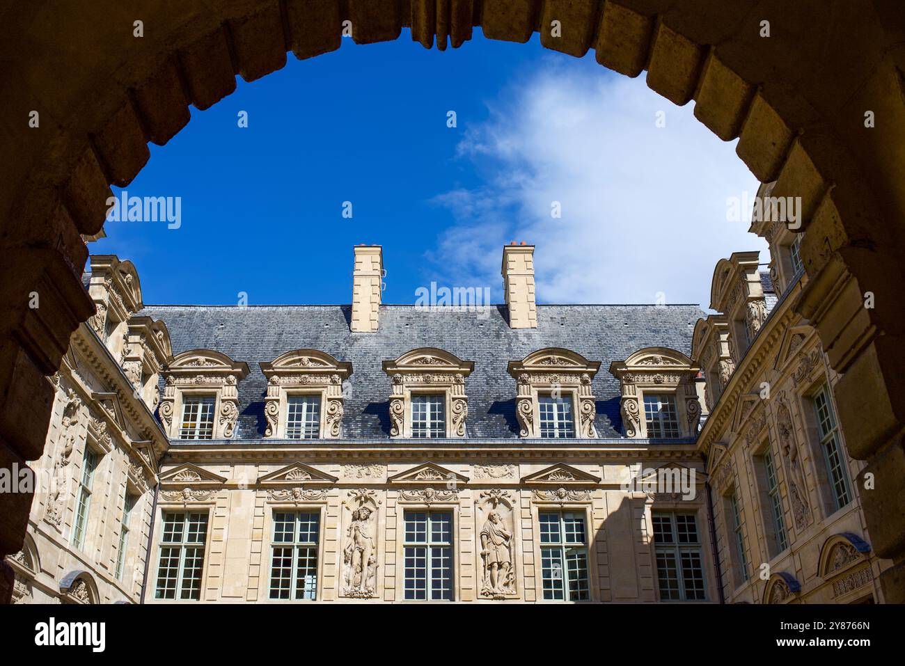 Paris, France, View through the arch on beautiful architectural details of the facade of the 'hôtel de Sully' in the Marais. Historical monument Stock Photo