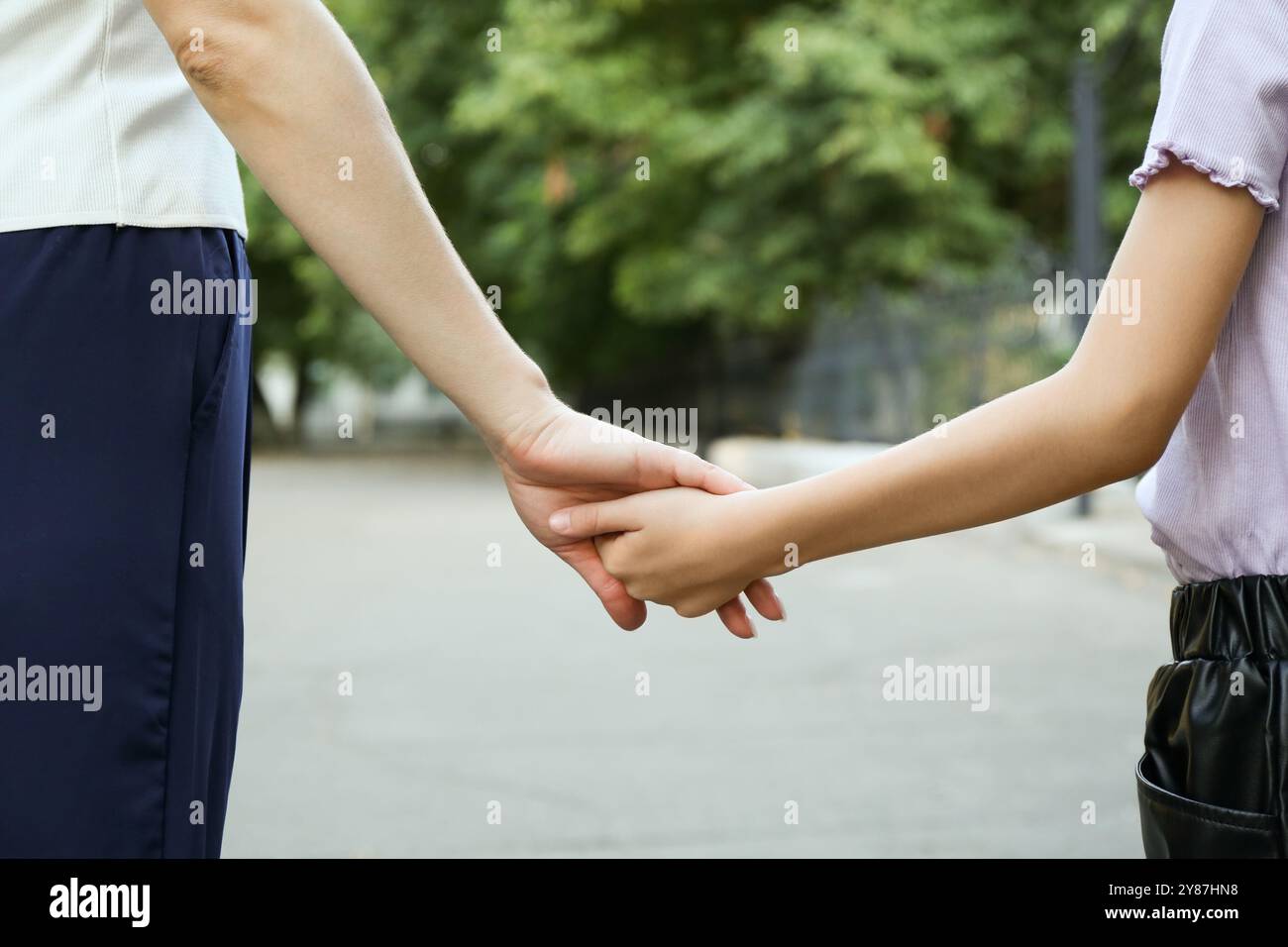 Mother and daughter holding hands outdoors, closeup Stock Photo - Alamy