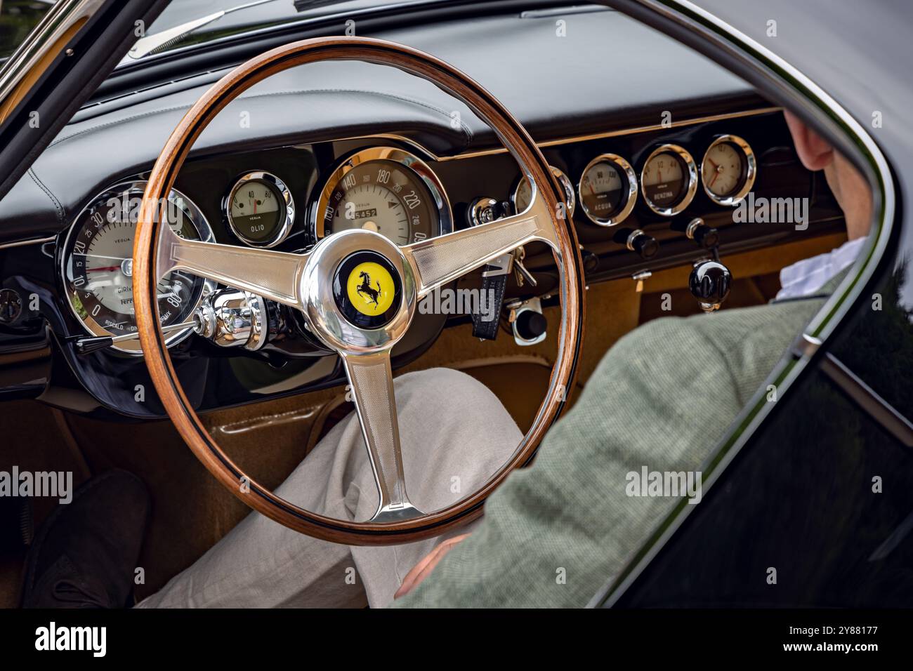 Man sitting and showing interior dash of 1962 Ferrari 250 GT Berlinetta SWB. Concours of Elegance 2024, Hampton Court Palace, London, UK Stock Photo